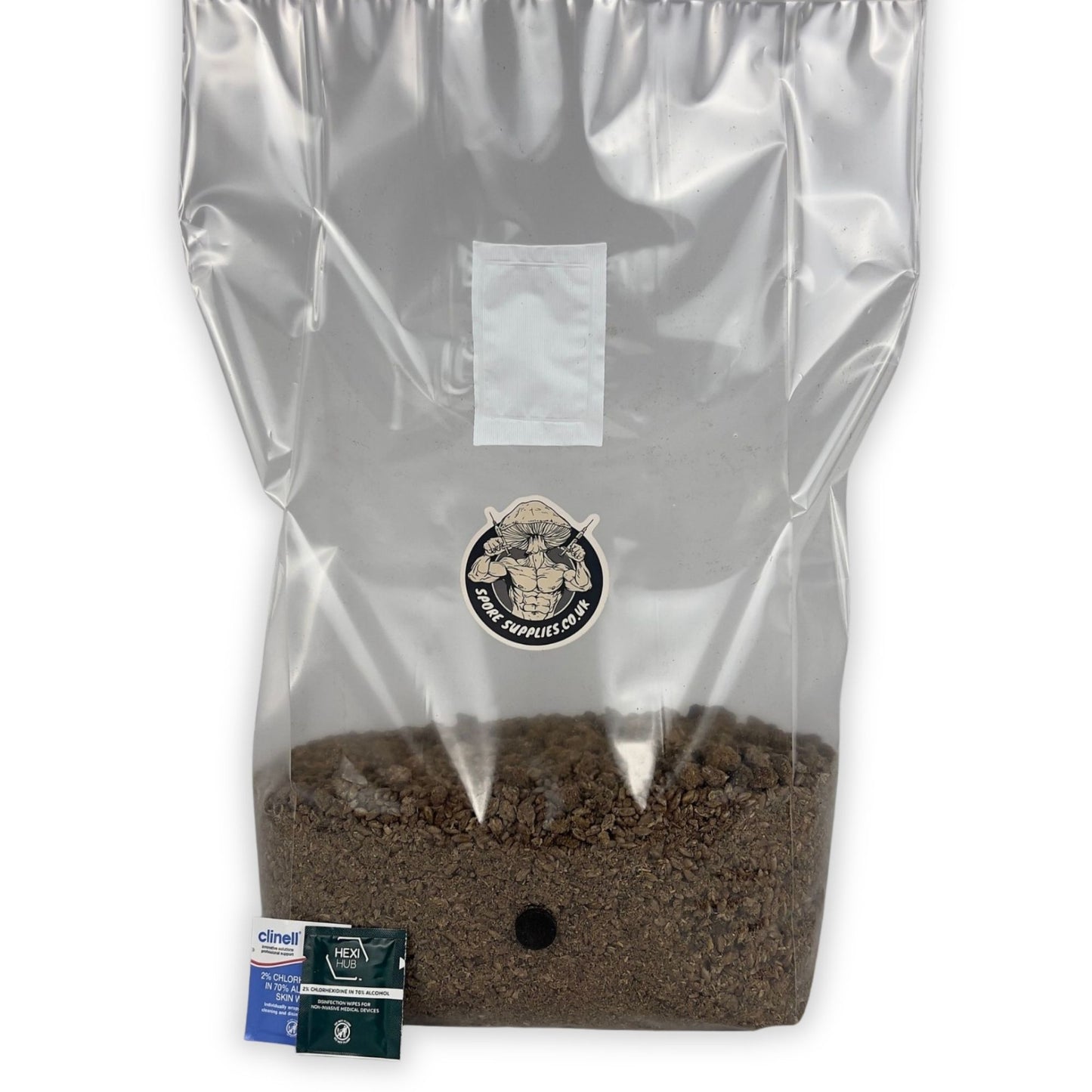 A clear plastic bag filled with brown wood based all in one substrate, sealed and labeled, with a small set of isopropyl wipes next to it.