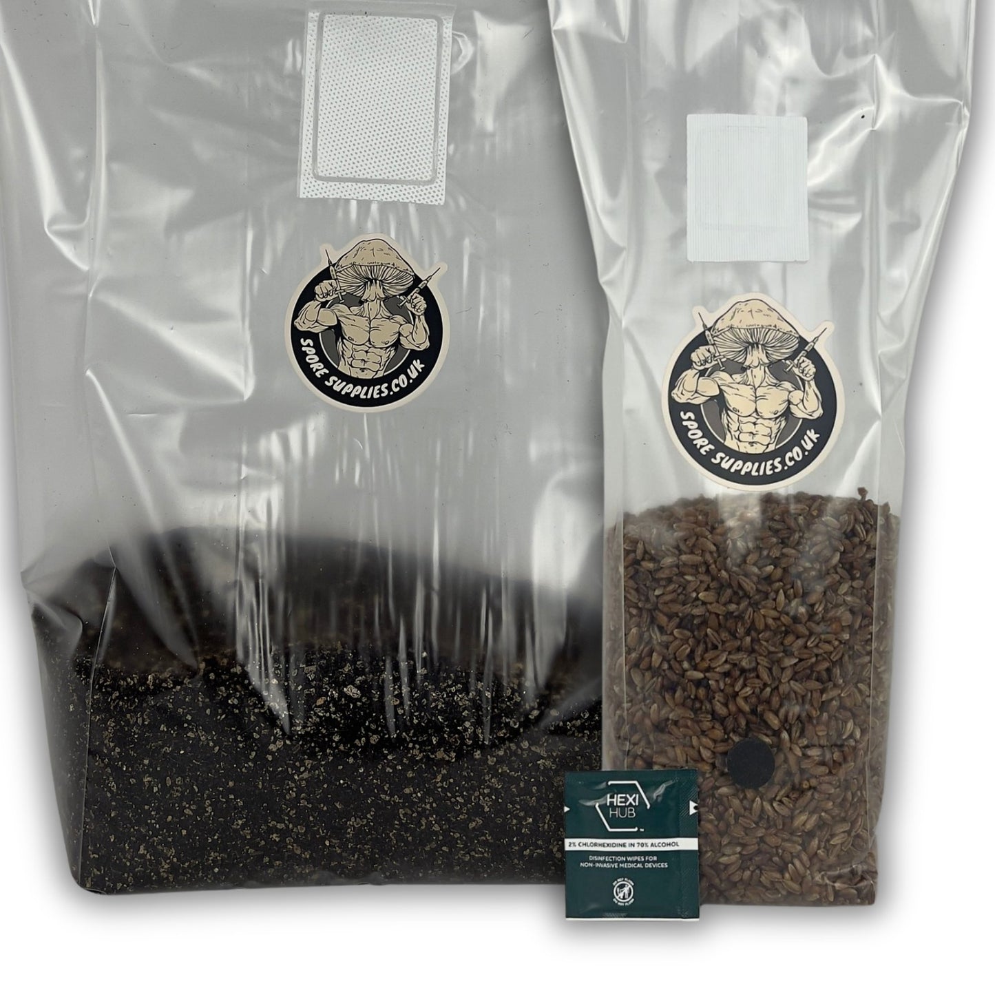 two plastic mushroom grow bags, one containing sterile cvg substrate, the other containing sterile rye grain. With one green isopropyl wipe in front of both bags